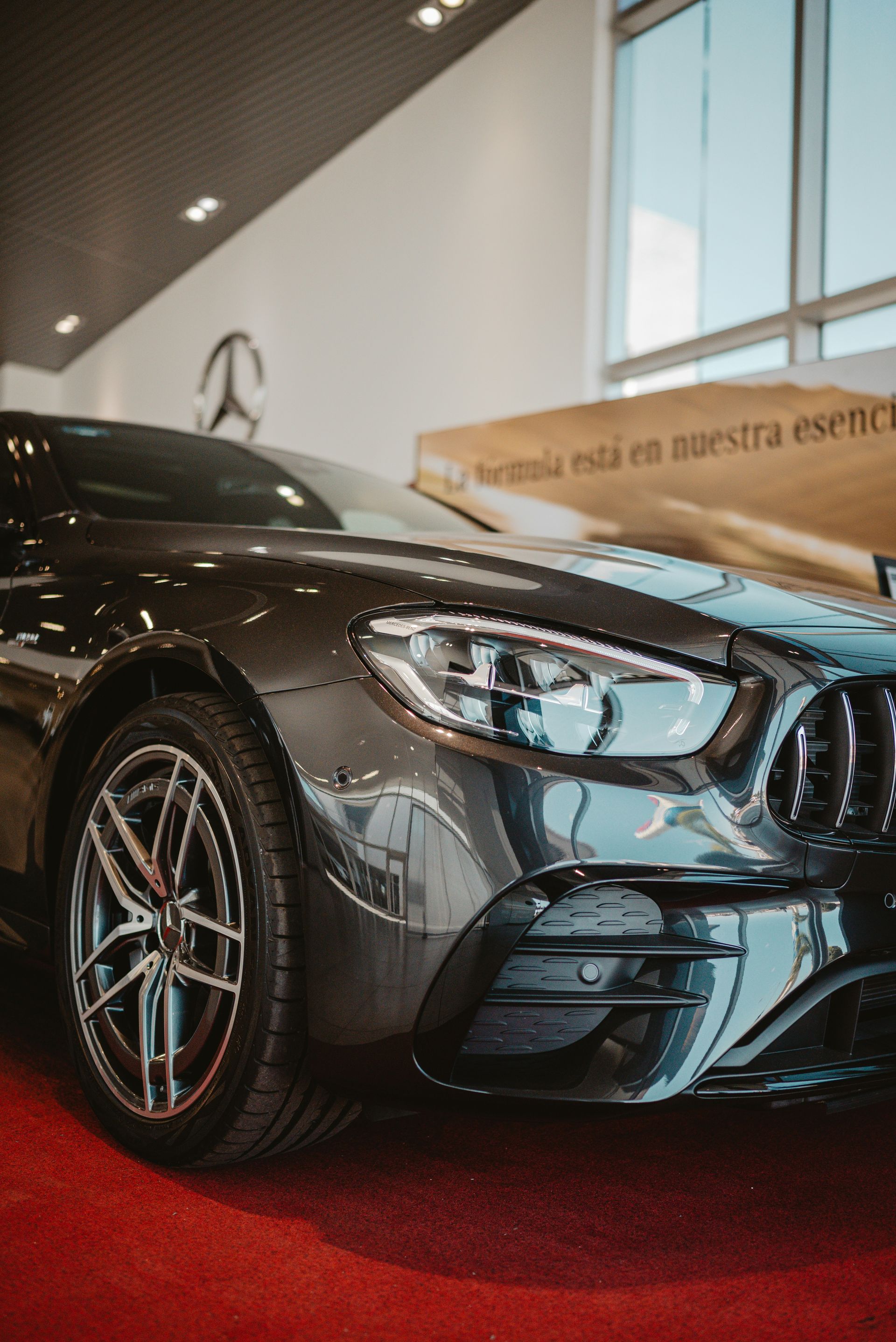 A dark luxury car parked inside a showroom